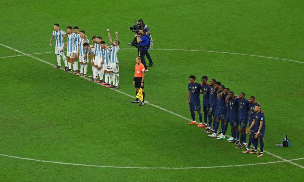 penalty shootouts of a group of football players standing in a line on a field